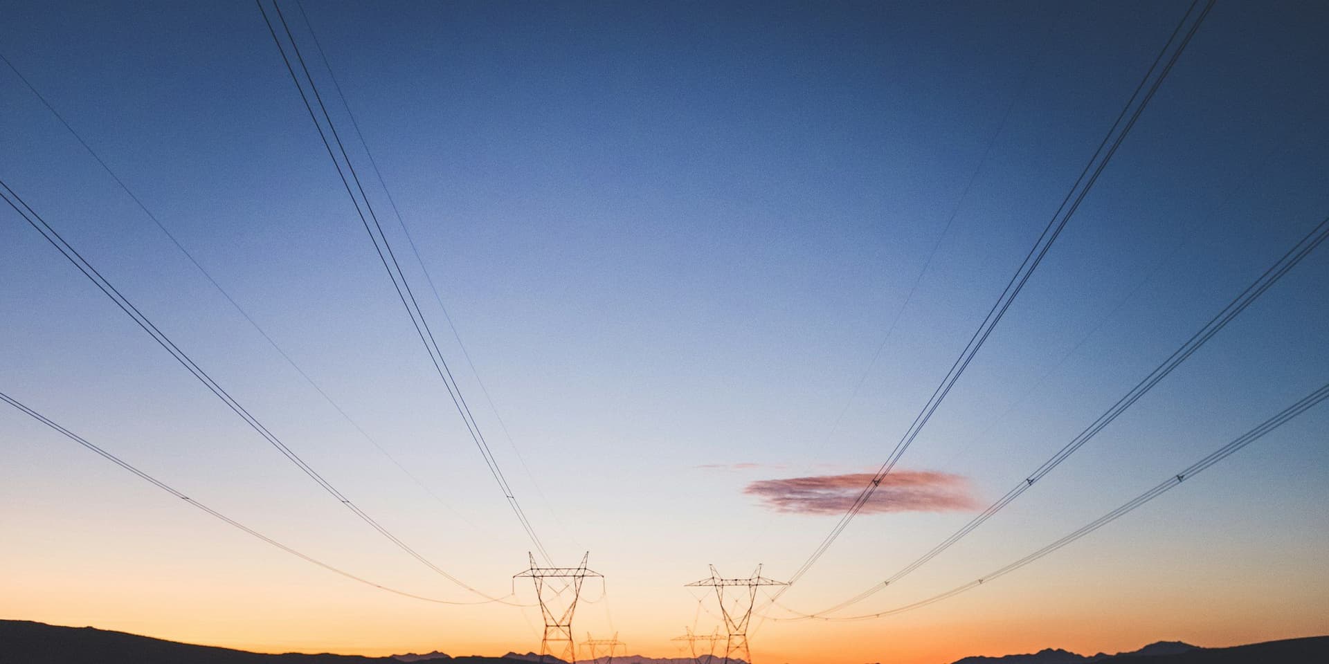 High-voltage transmission lines at sunset